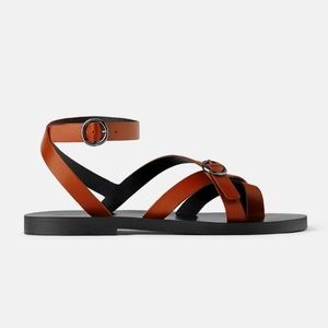 Flat leather sandals with cris-cross straps.